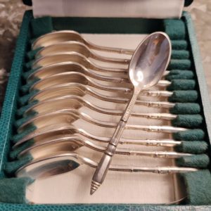 Coffret de 12 cuillères à moka ou espresso en métal argenté de la maison ERCUIS, modèle de style Art Déco au manche « à la russe » ciselé.